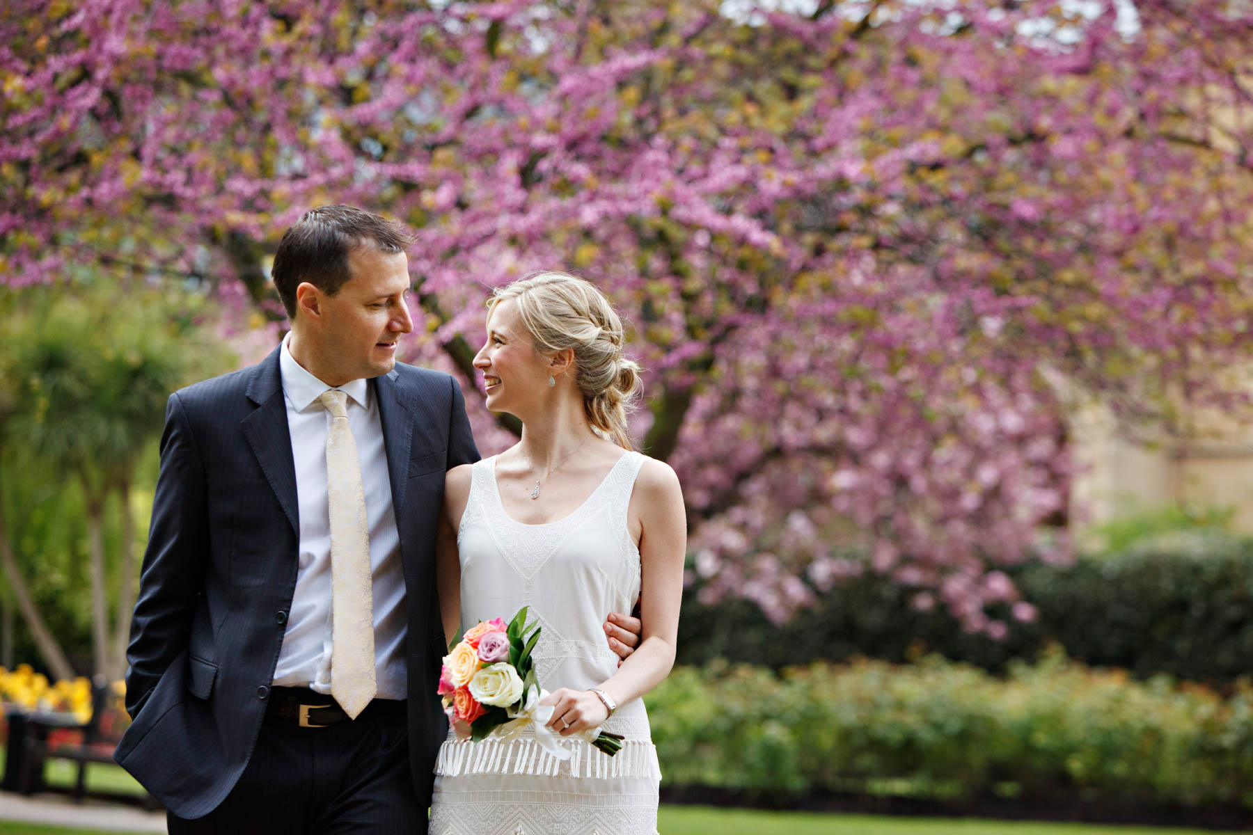 Spring wedding portrait in the park with pink cherry blossom in the background, after these newlyweds eloped to Chelsea Old Town Hall.