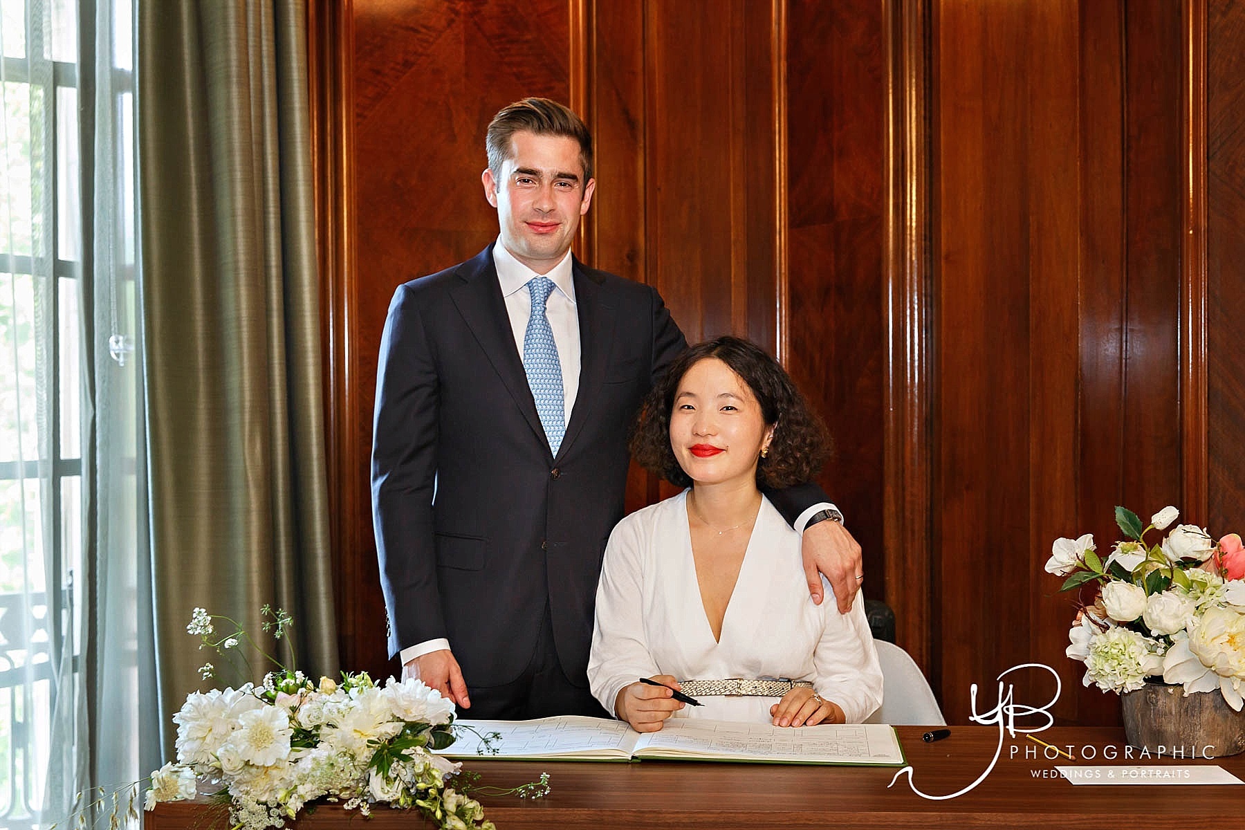 The bride and groom Janie and Jonathan pose for a formal wedding photo after signing the register in Westminster's Marylebone Room. 