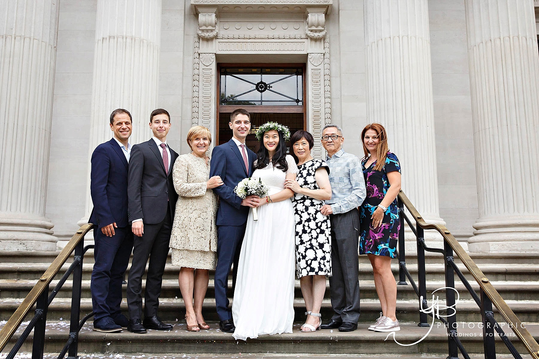 A family group photo of the bride and groom and their relatives after their registry office marriage ceremony. 