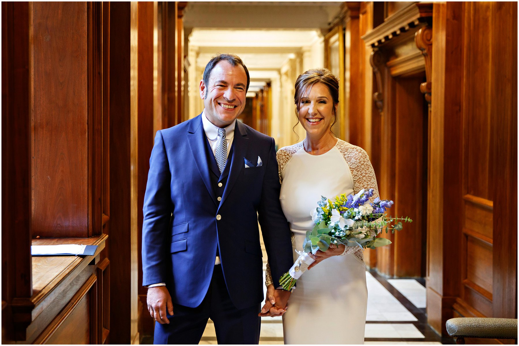 Bride and Groom wait in anticipation in the hallway of Old Marylebone Town Hall to enter their Soho Room ceremony