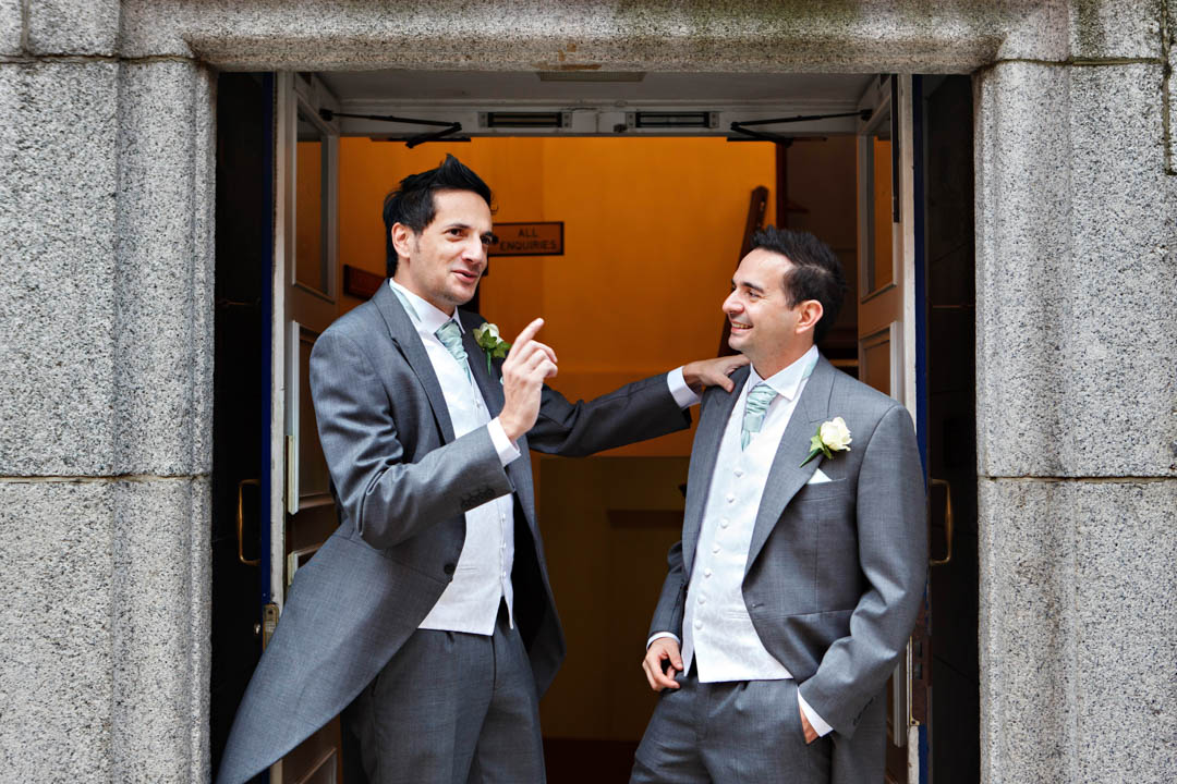 The best man has a few last minute bits of advice for the groom in the entrance of Chelsea Old Town Hall.