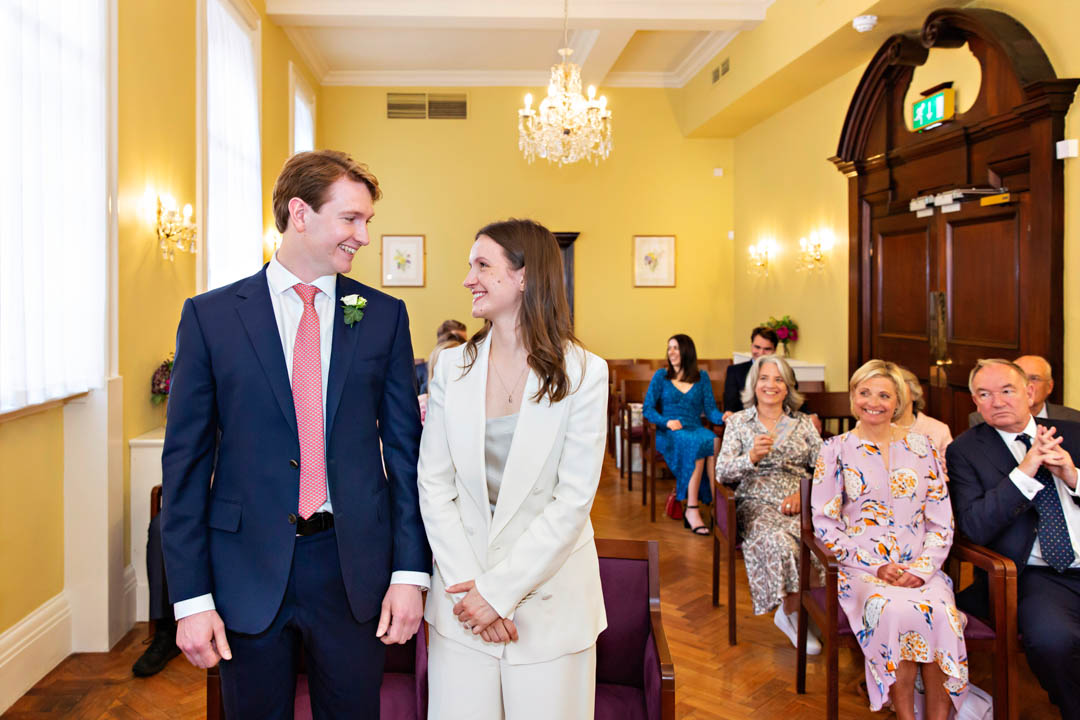 Bride and groom gaze at each other lovingly during their wedding ceremony in the Brydon Room
