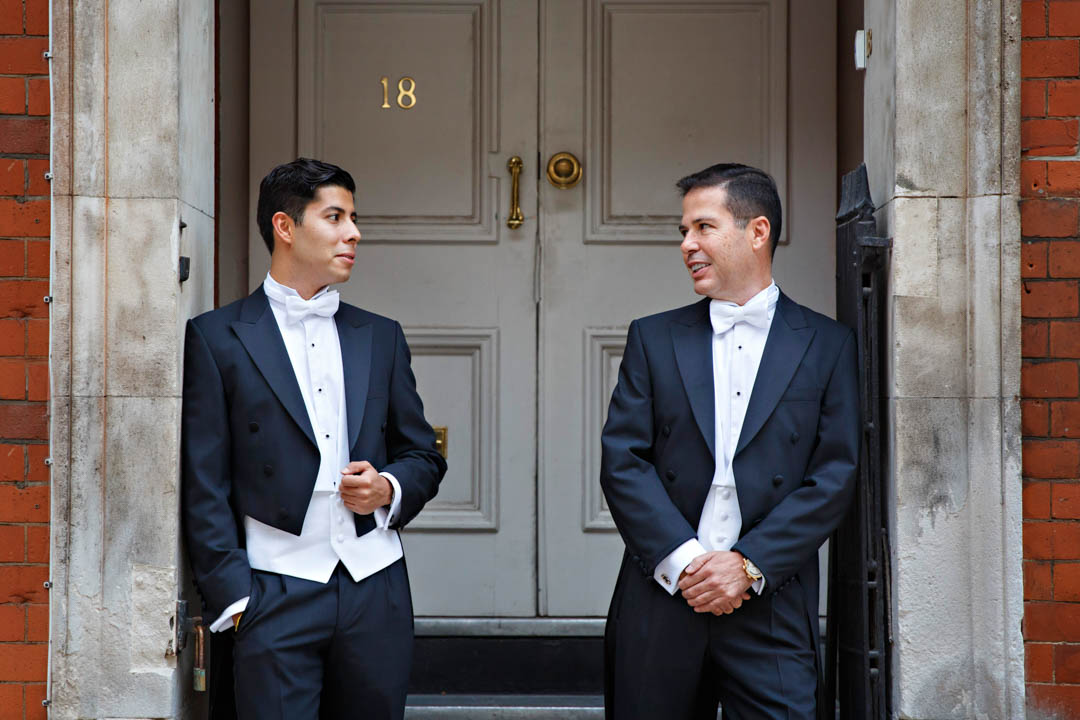 Two stylish grooms in tuxedos pose for their same sex wedding portraits after their Chelsea civil wedding.