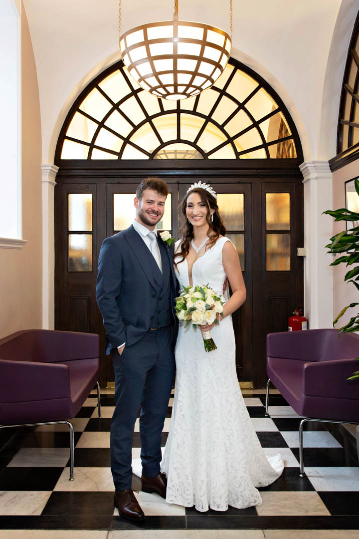 Stylish bride and groom pose for a portrait before their Chelsea civil wedding
