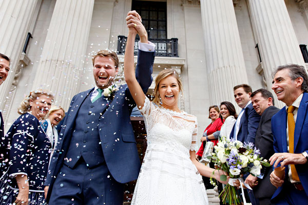 Bride and Groom surrounded by confetti on the steps of The Old Marylebone Town Hall