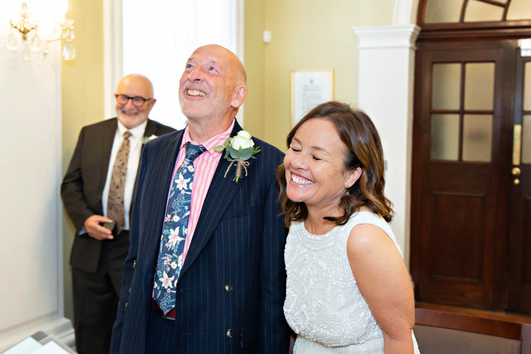 A bride and groom giggle in the midst of their Rossetti Room wedding at Chelsea Old Town Hall.