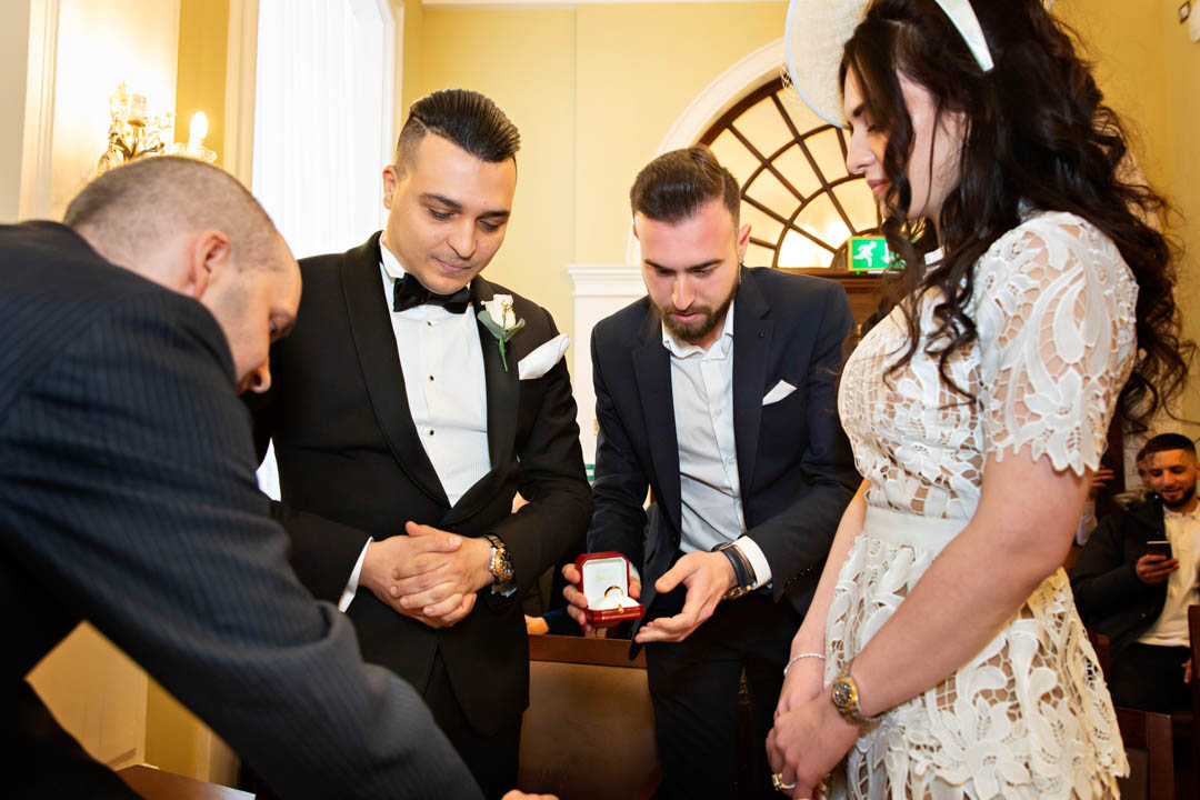 The best man hands over the wedding rings to the registrar in the Rossetti Room.