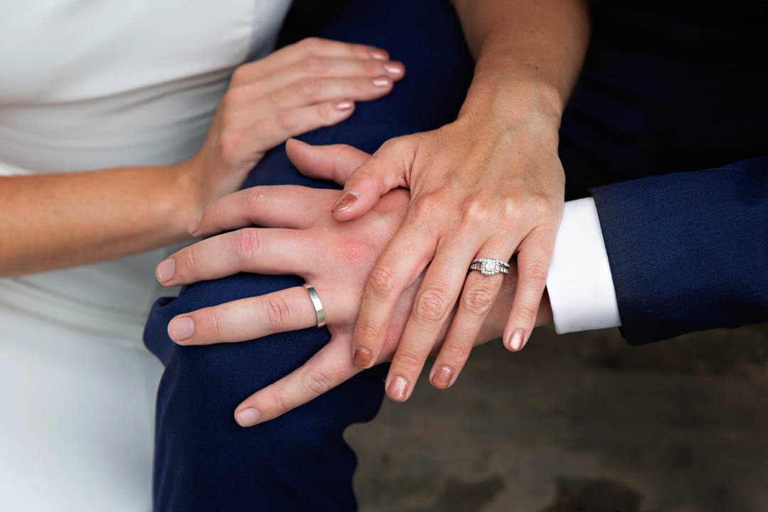 Platinum wedding bands for the bride and groom. The couple's hands rest on each other to show off their new rings, after marrying at Chelsea's Rossetti Room on the Kings Road.