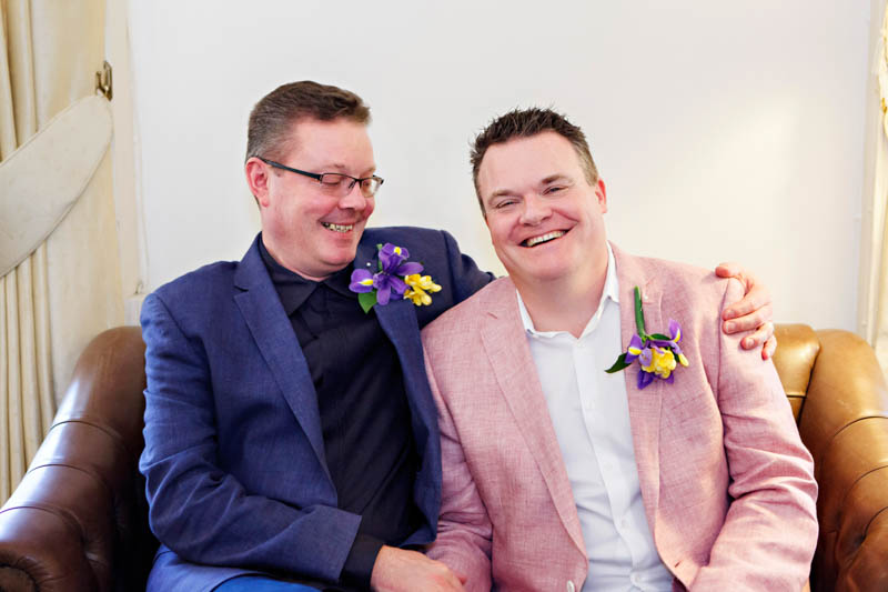 Two grooms cuddle up in the waiting room ahead of their civil partnership ceremony at Southwark register office.