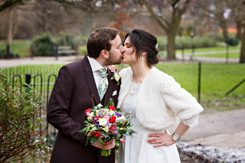 The newlyweds share a kiss in the park after their civil wedding ceremony.