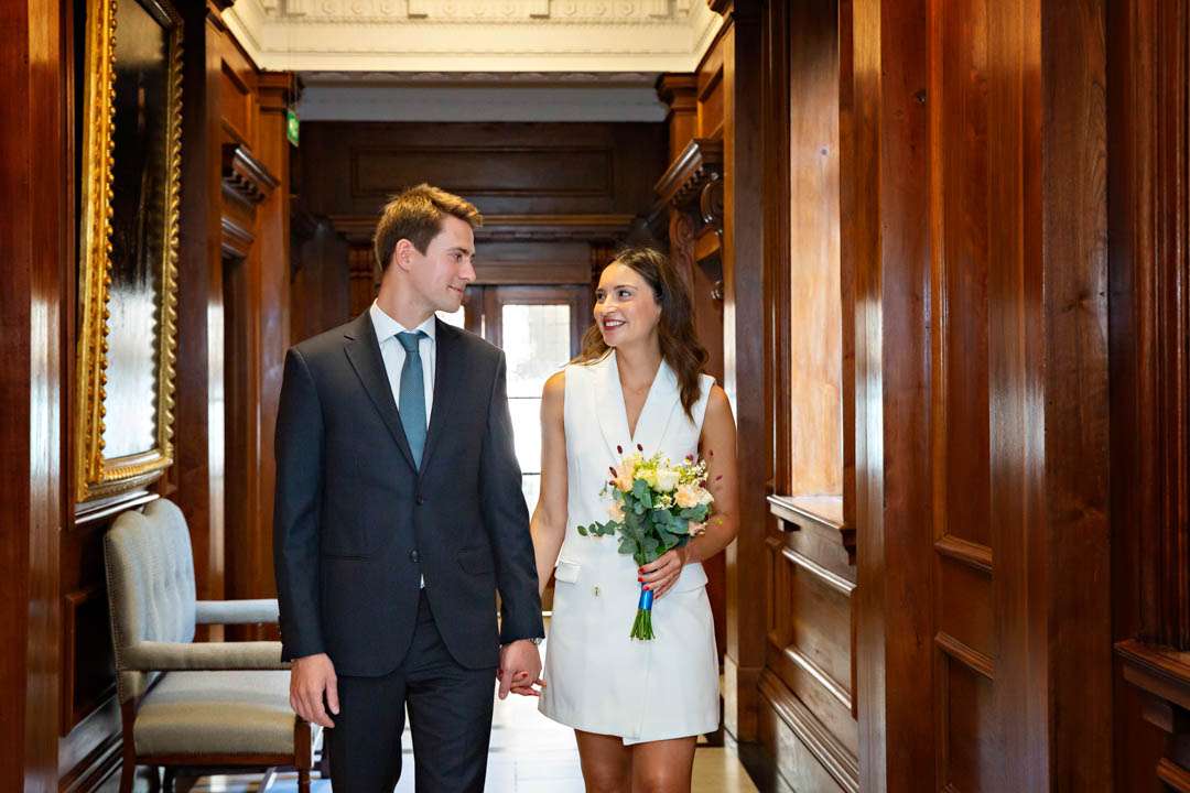 Bride and groom walk through the wood panelled hallways of Old Maryelebone Town Hall, following their Knightsbridge Room civil wedding.