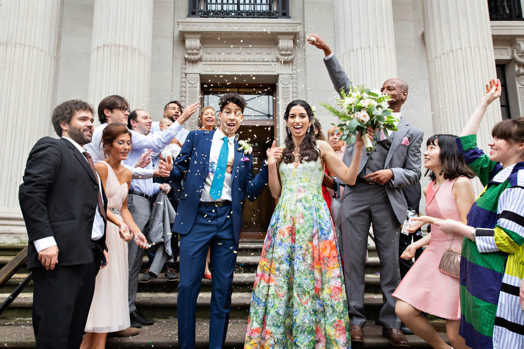 Bride and groom exit Old Marylebone Town Hall into a fully roof confetti after their Knightsbridge Room wedding ceremony.
