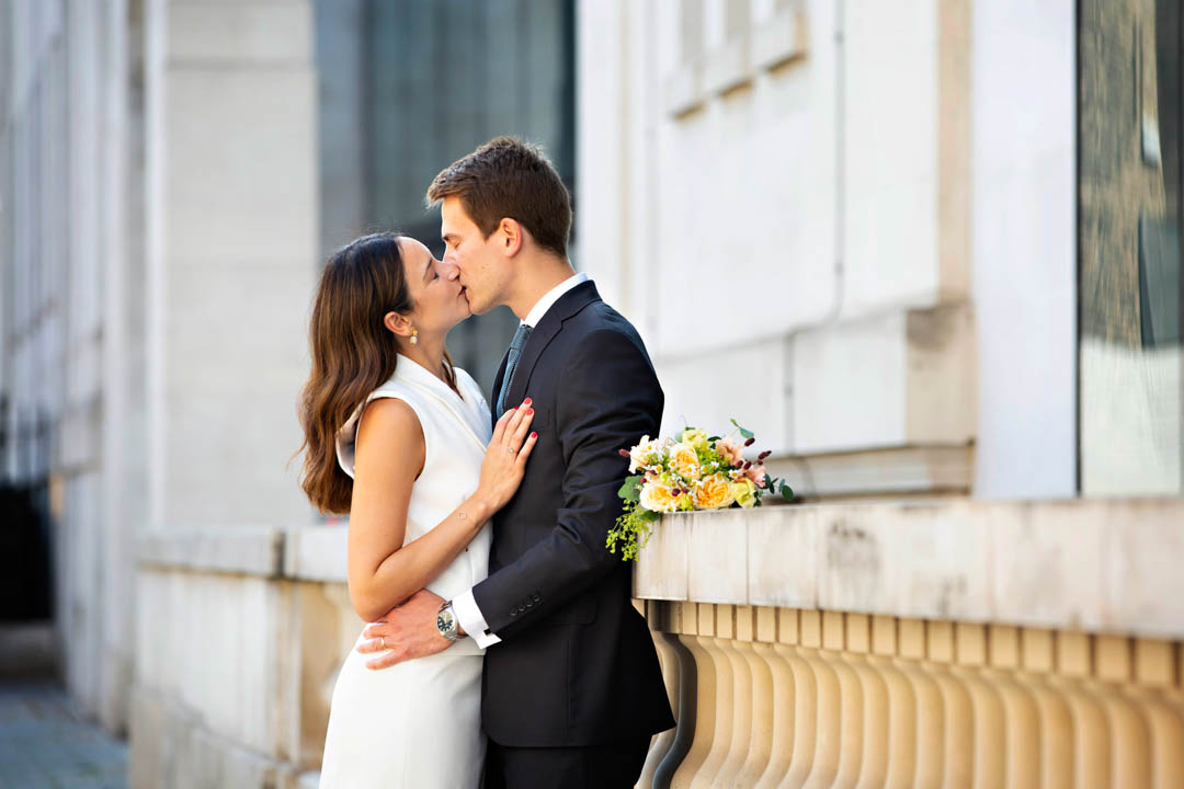 Bride and groom kiss during romantic wedding portrait session