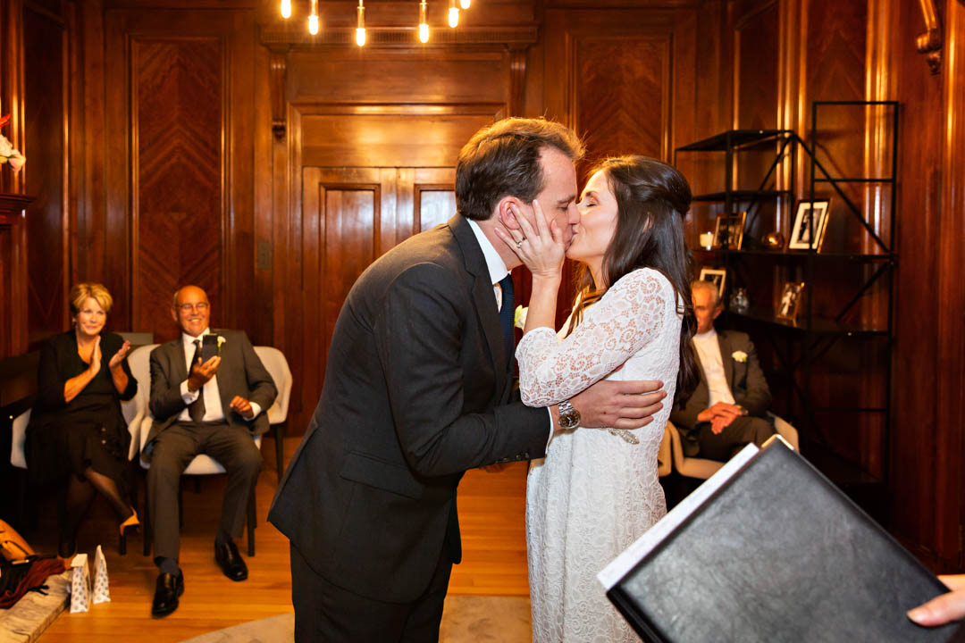 A bride and groom kiss for the first time as husband and wife during their register office wedding.