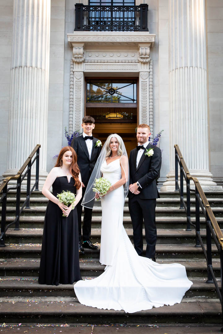 Super elegant portrait of the bride in her Pronovias dress with her children who are all dressed in black for this black and white wedding in the Marylebone Room.