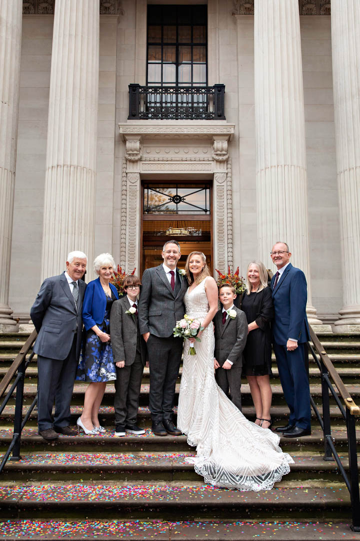 A small wedding party poses for their formal group photo on the steps of Old Marylebone Town Hall.