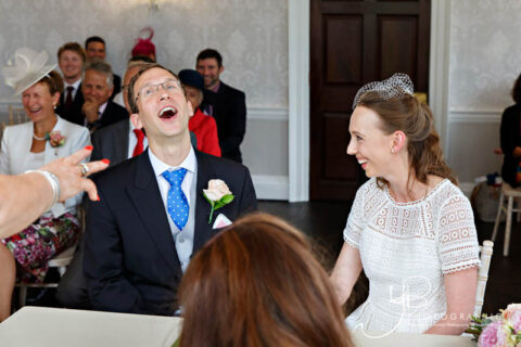 The groom laughs out load during a civil wedding at Merton Register Office.