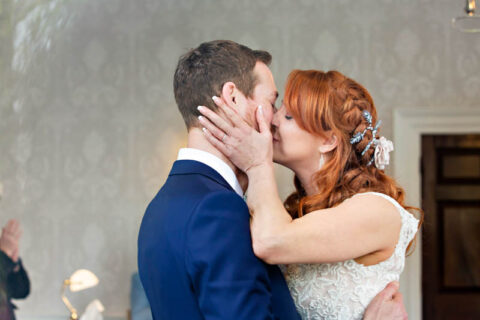 The bride and groom share a kiss at the end of their wedding ceremony at Morden Park House.