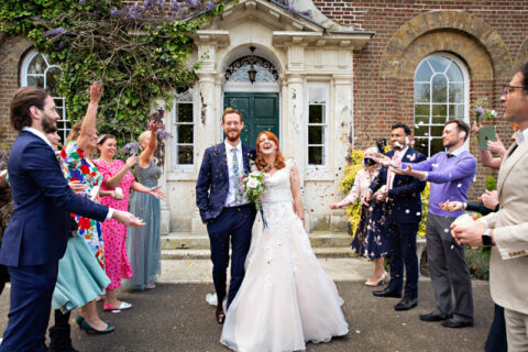 Bride and groom are covered in confetti to celebrate the end of their civil wedding at Morden Park House.