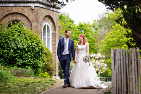 Newlyweds go for a romantic stroll past Morden Park House after their Merton Register Office civil wedding ceremony.