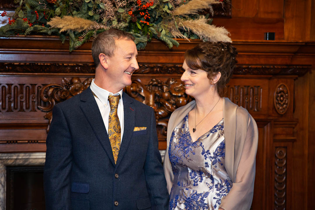 A bride and groom gaze into each others' eyes as they exchange wedding vows in the wood-panelled Paddington Room.