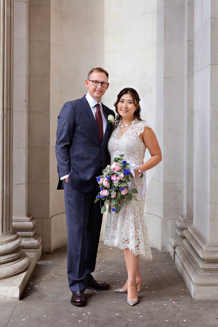 A classic wedding portrait of a bride and groom posing after their Paddington Room wedding. The bride is wearing a pretty lace dress.