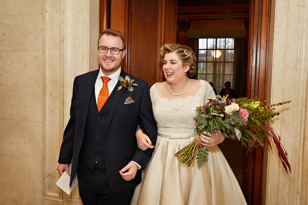 A bride and groom exit the Westminster room after their civil wedding ceremony.