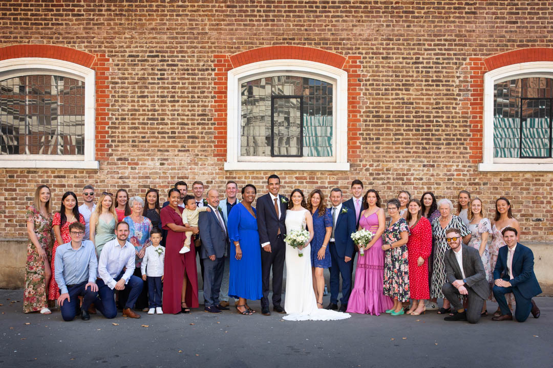 A wedding party is beautifully arranged for a formal group photograph after the couple's civil wedding ceremony in the Mayfair Room.